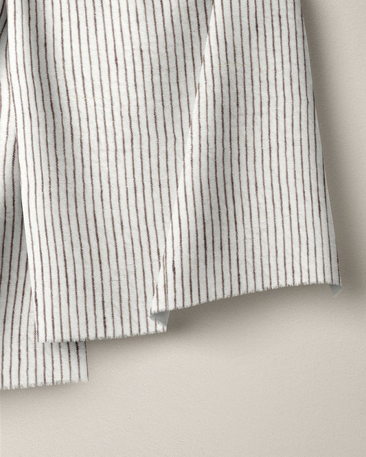 Close-up of a striped fabric with black and white lines on a beige background