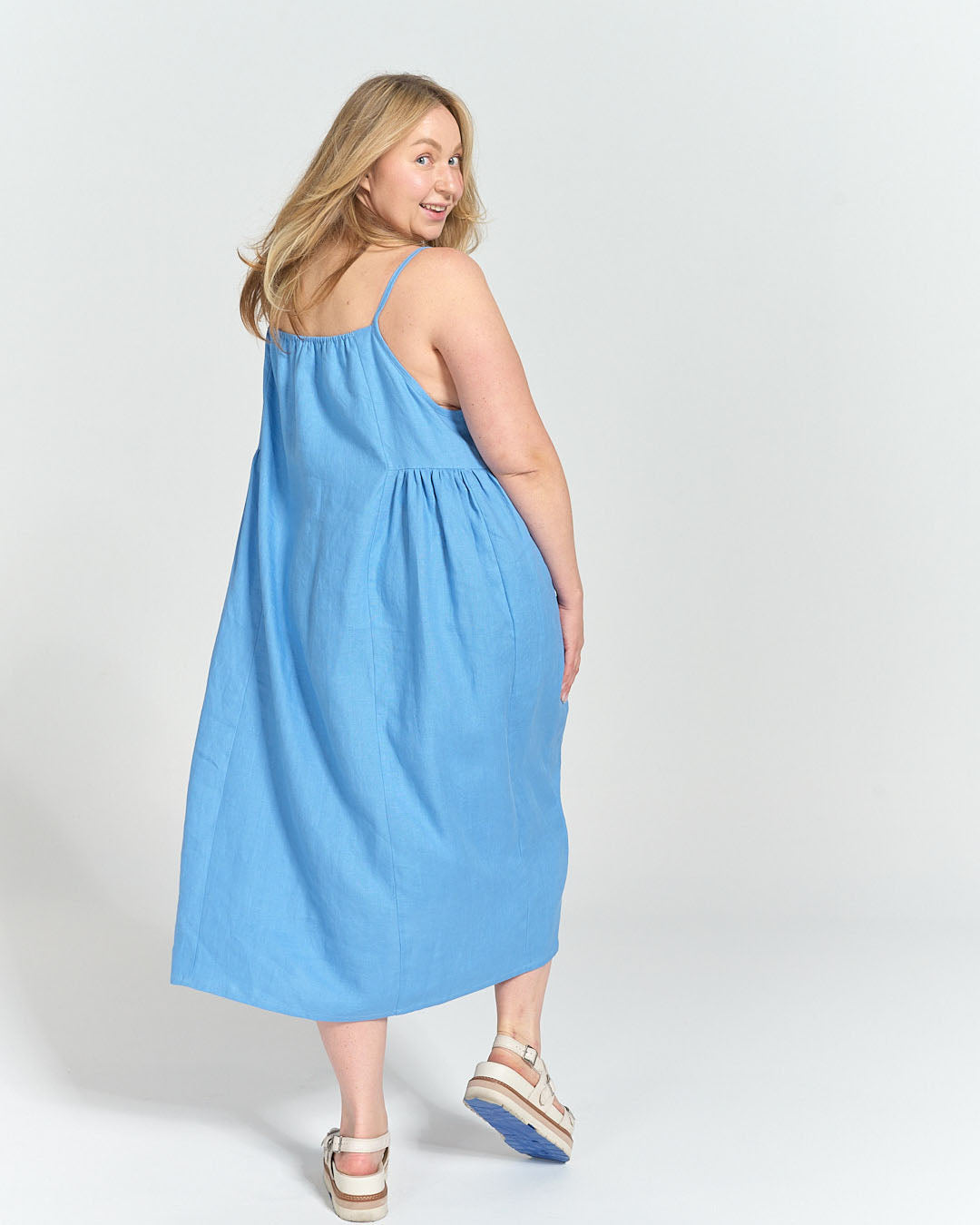 Model twirling in the finished sundress in blue linen