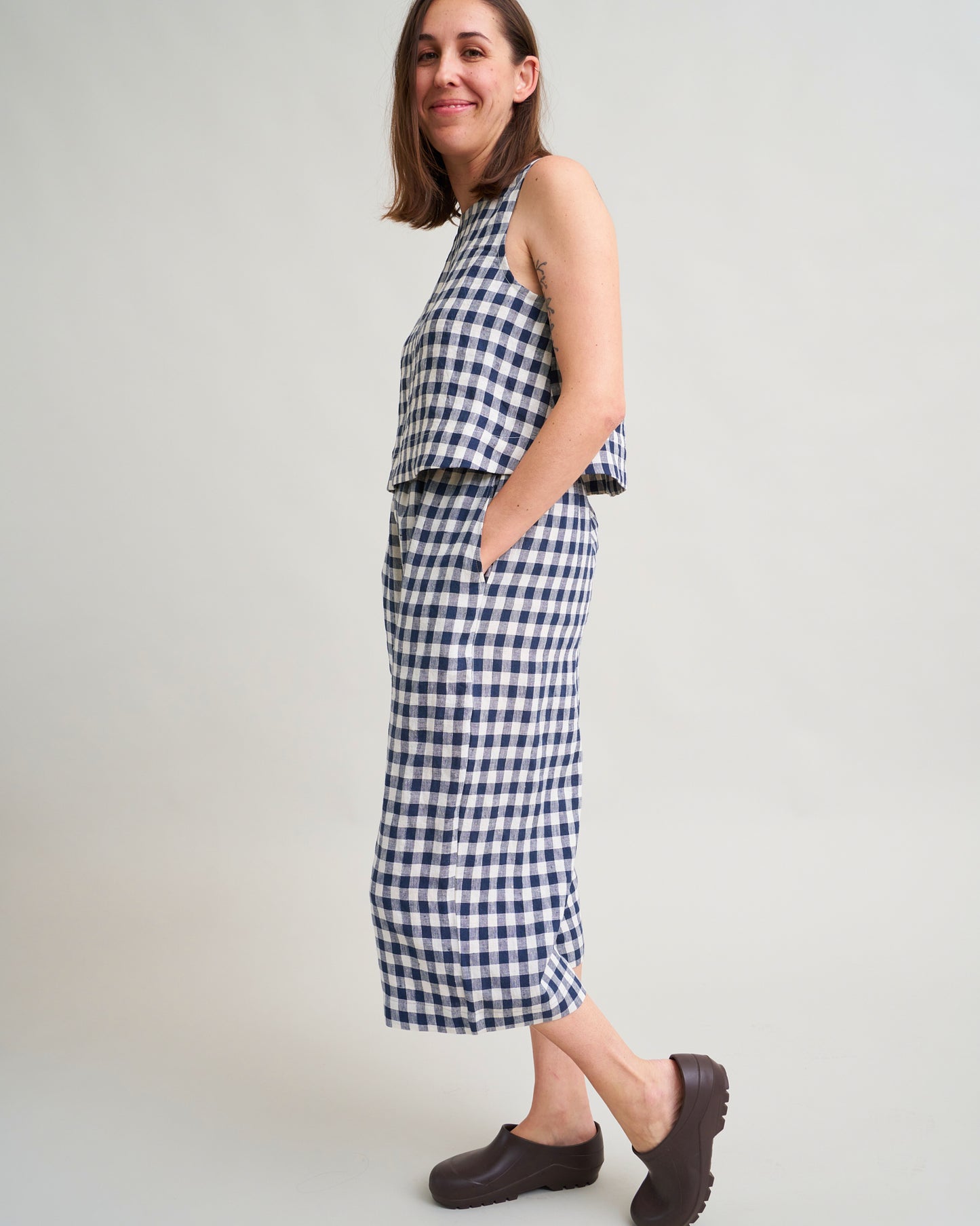Woman wearing a blue and white gingham matching set on a plain background