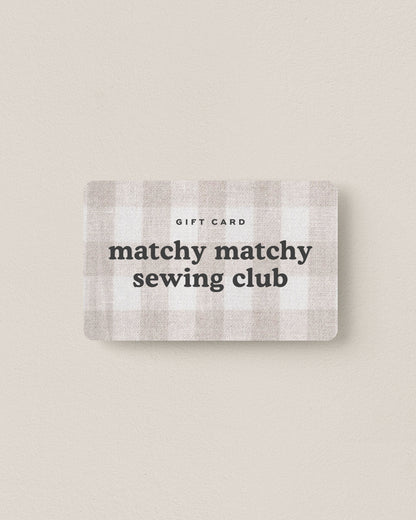 A digital gift card with a plaid pattern design, displaying the text 'matchy matchy' branding.
